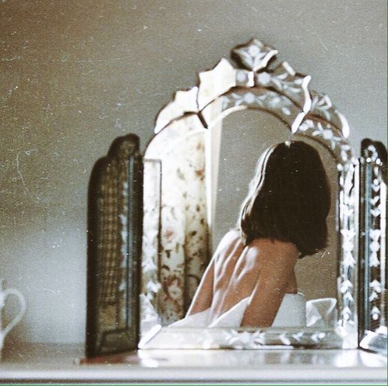 Chica oriental reflejada en un espejo, a primera hora de la mañana