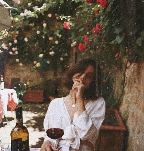 Chica oriental en un almuerzo con una copa de vino en su mano.